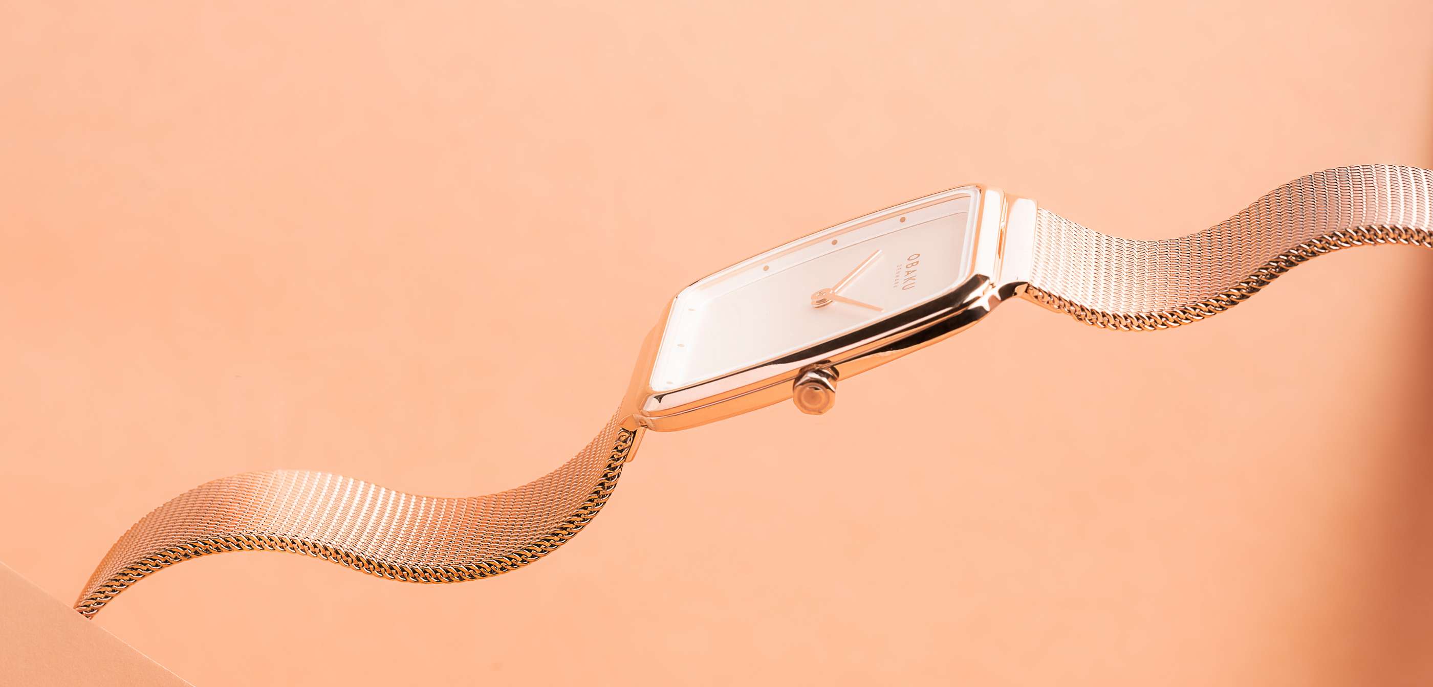 Ultra-slim rose gold watch against a salmon background